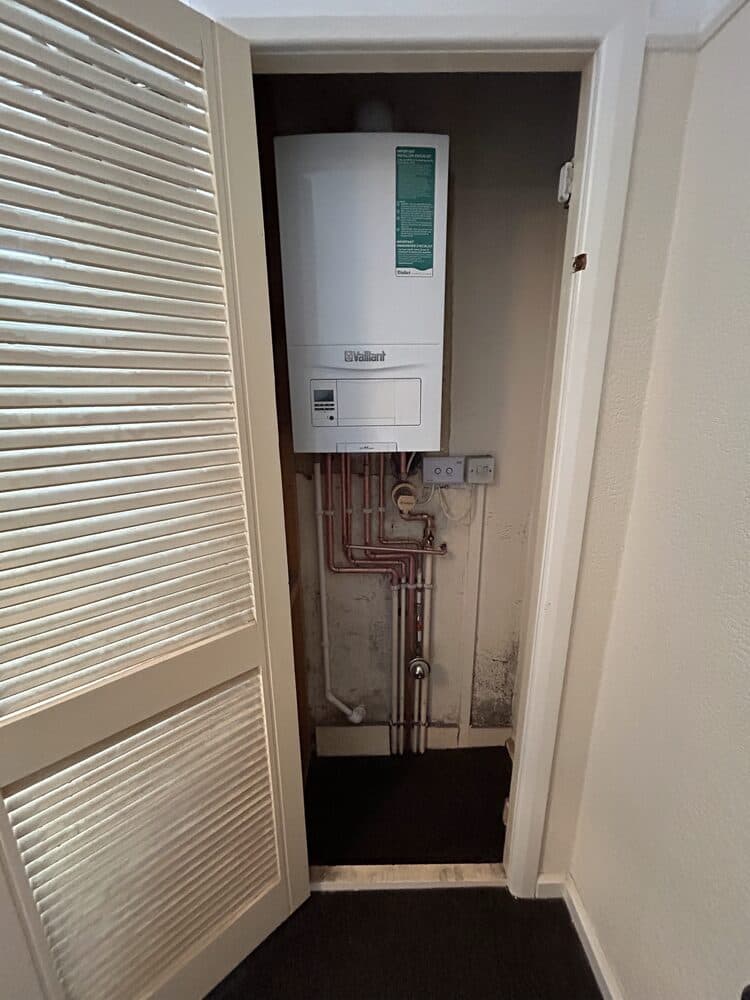 Combi boiler installed in a narrow utility cupboard