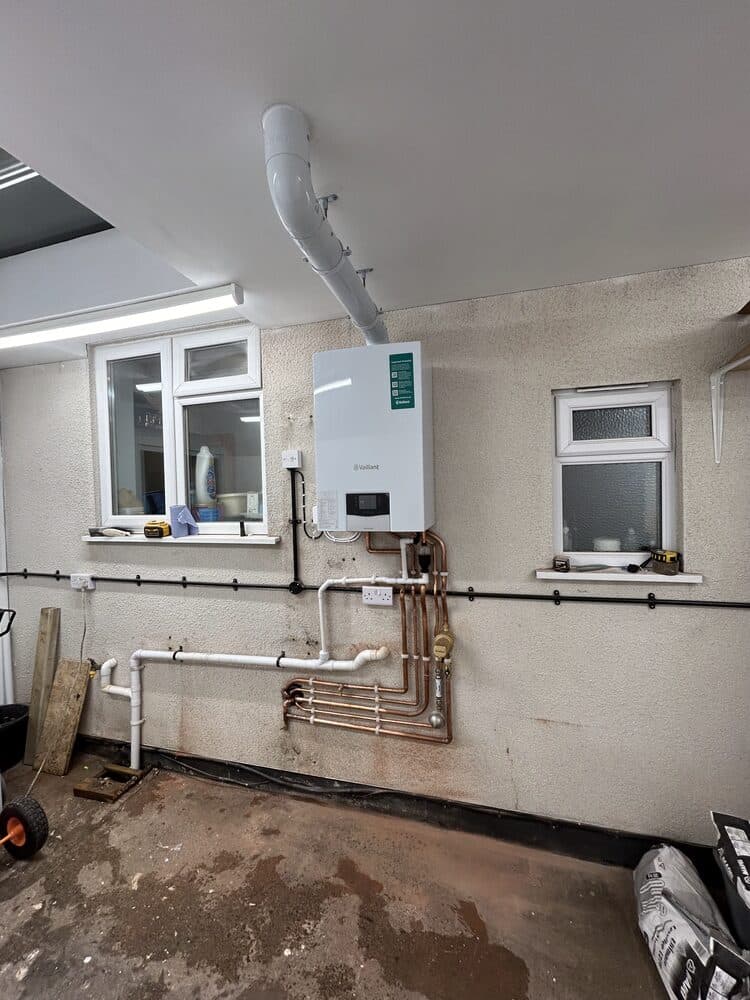 Boiler installed above a utility area with exposed pipework
