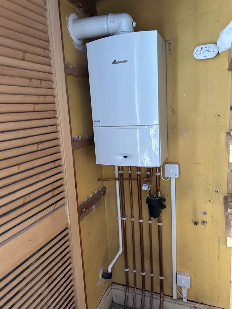 Worcester Bosch boiler neatly installed against a wood panel wall