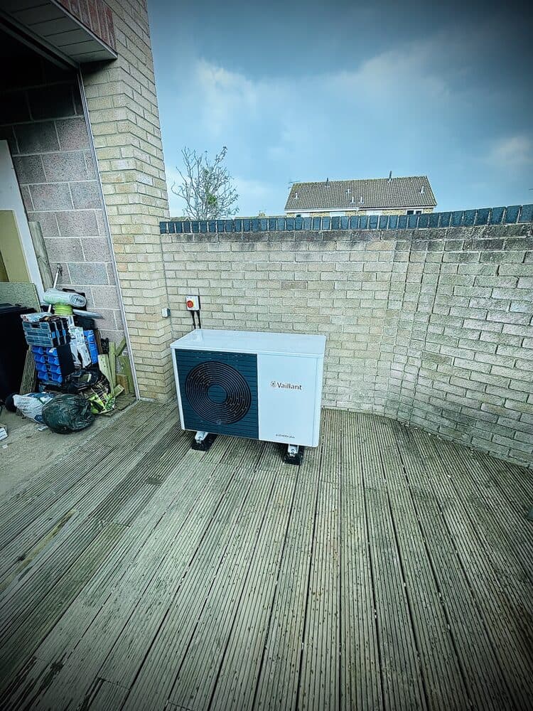 Air source heat pump outdoor unit installed on garden decking
