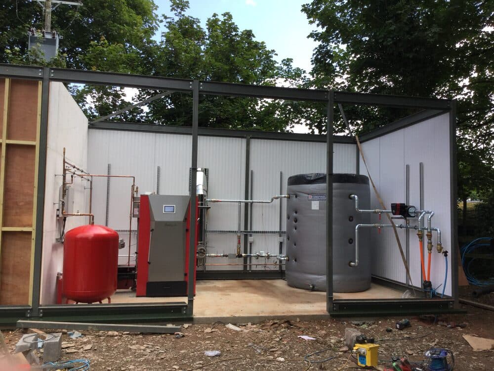 Outdoor plant enclosure housing a boiler, pressure vessel, and buffer tank